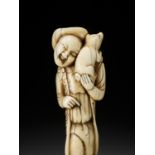 A GOOD IVORY NETSUKE OF A DUTCHMAN WITH DOG