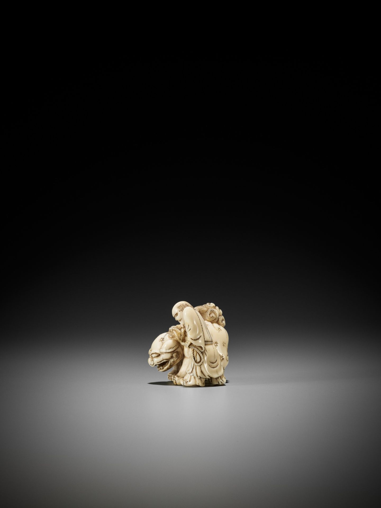 AN IVORY NETSUKE OF A FOREIGNER FROM SENHA LEADING A SHISHI - Bild 7 aus 12