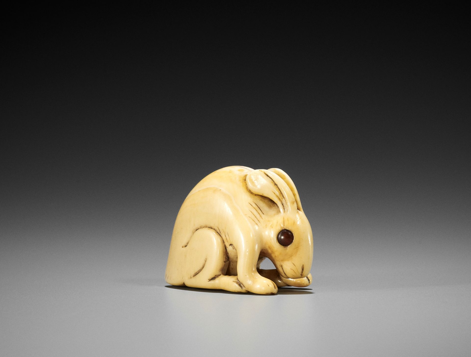 A KYOTO SCHOOL IVORY NETSUKE OF A HARE