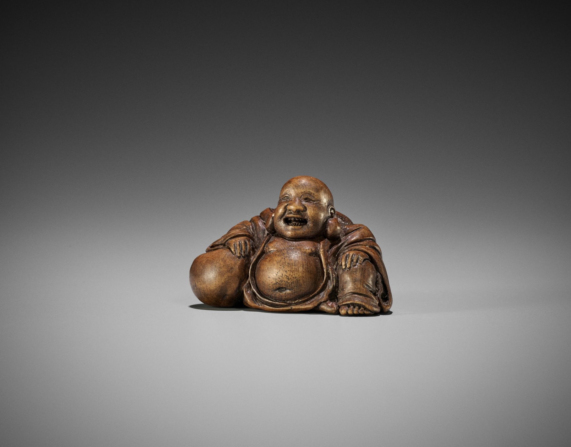 A FINE WOOD NETSUKE OF HOTEI