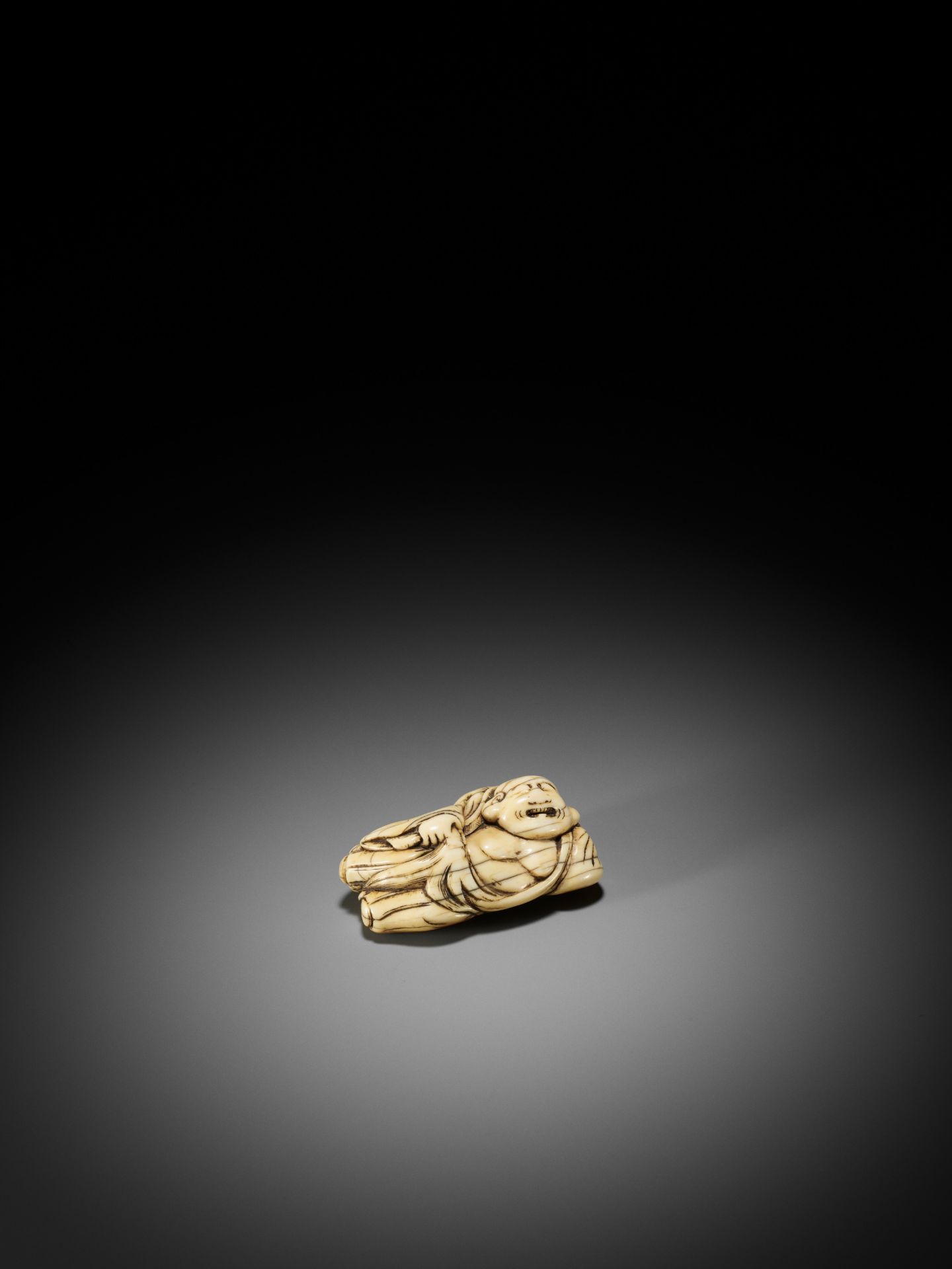 AN IVORY NETSUKE OF A RECLINING HOTEI WITH HOSSU (FLYWHISK) - Bild 4 aus 9