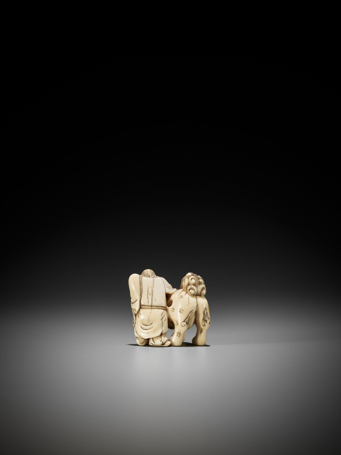 AN IVORY NETSUKE OF A FOREIGNER FROM SENHA LEADING A SHISHI - Bild 8 aus 12