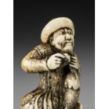 AN IVORY NETSUKE OF A DUTCHMAN COMBING HIS BEARD