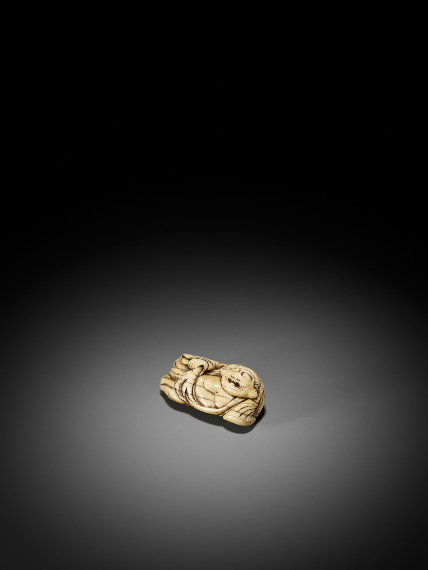 AN IVORY NETSUKE OF A RECLINING HOTEI WITH HOSSU (FLYWHISK) - Bild 6 aus 9