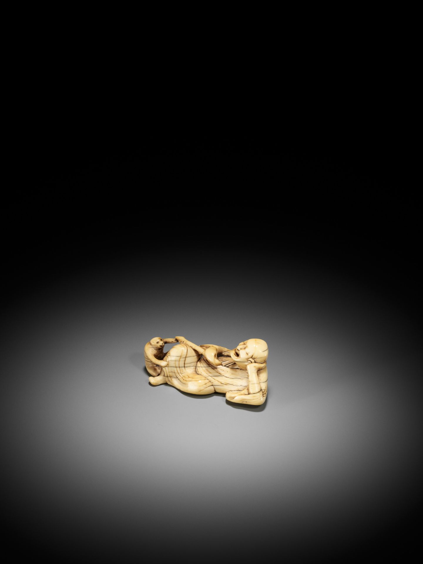 A RARE AND LARGE IVORY NETSUKE OF A RECLINING SARUMAWASHI AND HIS MONKEY - Bild 4 aus 10