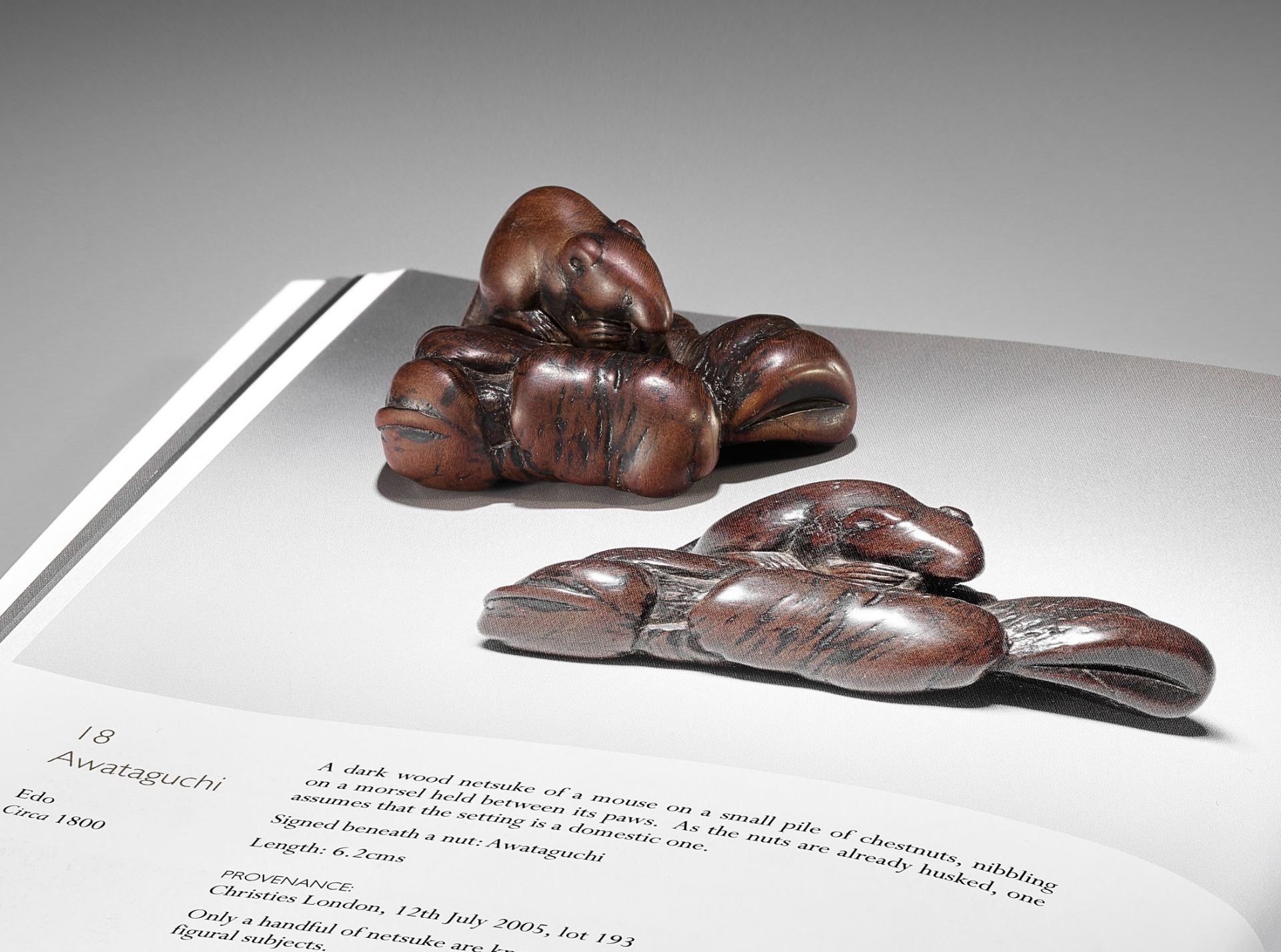 AWATAGUCHI: A LARGE OLD WOOD NETSUKE OF A RAT WITH CHESTNUTS
