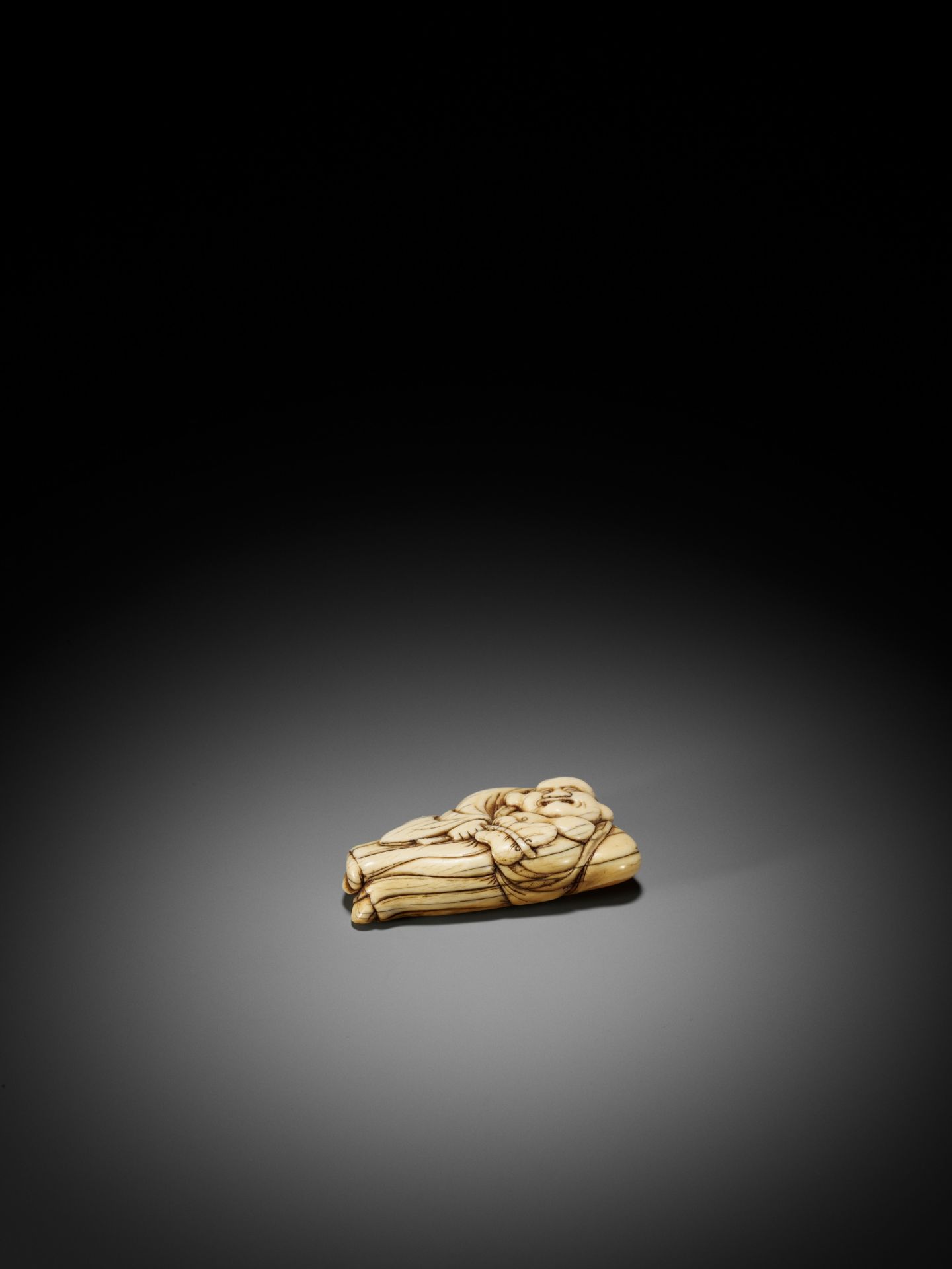 AN IVORY NETSUKE OF A RECLINING HOTEI WITH UCHIWA (FAN) - Bild 8 aus 8