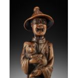 A VERY LARGE AND SUPERB WOOD NETSUKE OF A FOREIGNER WITH DOG