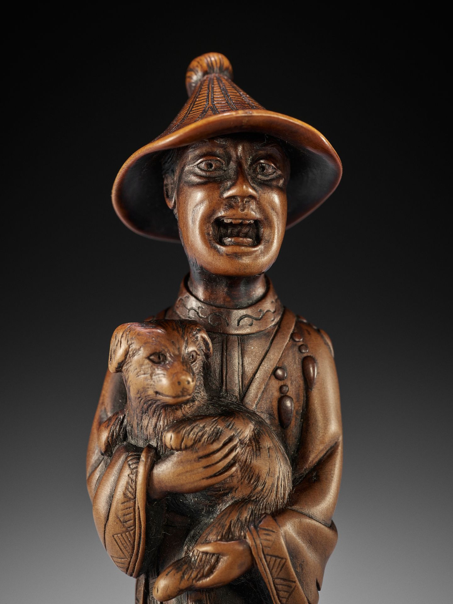 A VERY LARGE AND SUPERB WOOD NETSUKE OF A FOREIGNER WITH DOG