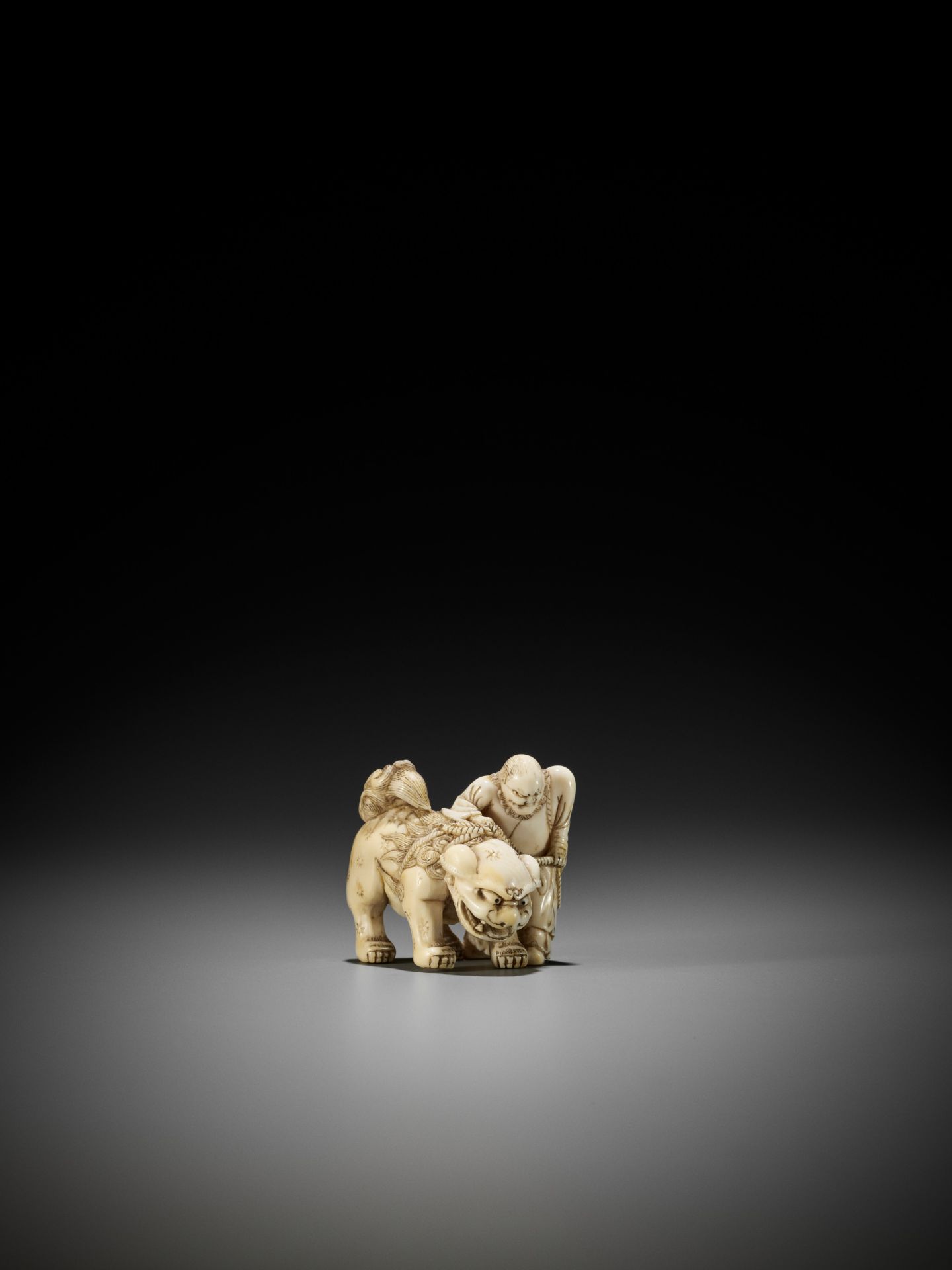 AN IVORY NETSUKE OF A FOREIGNER FROM SENHA LEADING A SHISHI - Bild 5 aus 12