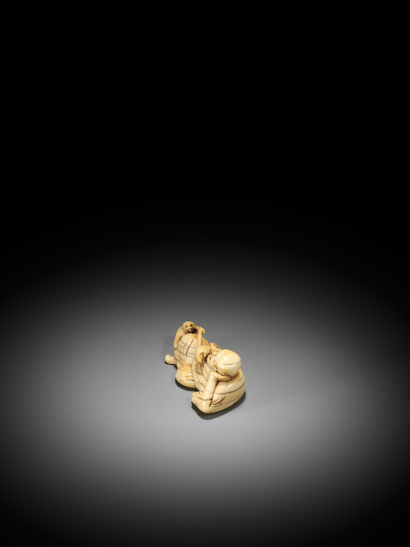 A RARE AND LARGE IVORY NETSUKE OF A RECLINING SARUMAWASHI AND HIS MONKEY - Bild 5 aus 10