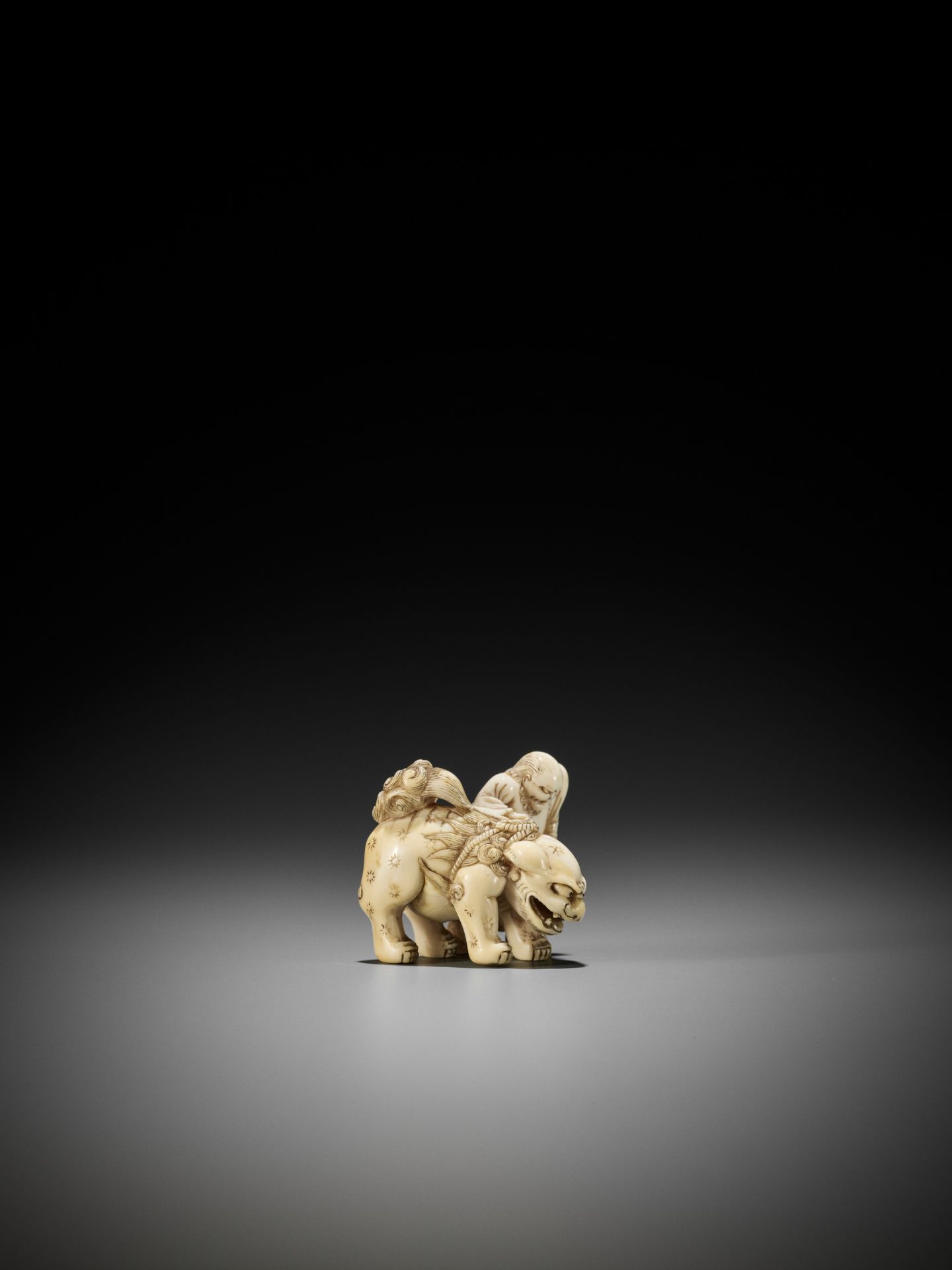 AN IVORY NETSUKE OF A FOREIGNER FROM SENHA LEADING A SHISHI - Bild 9 aus 12