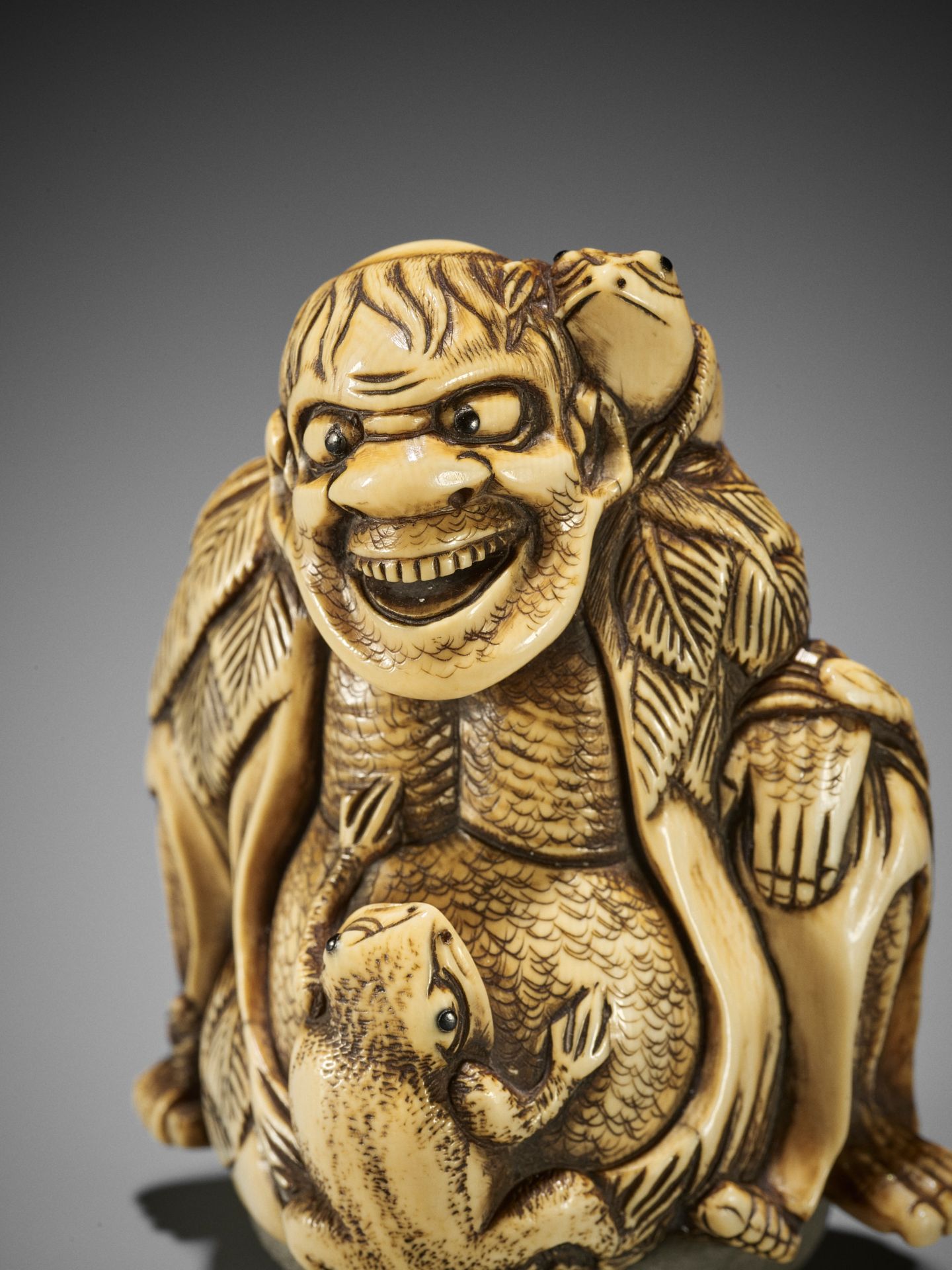 A MASSIVE IVORY NETSUKE OF GAMA SENNIN AND TWO TOADS