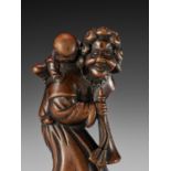 A GOOD WOOD NETSUKE OF A DUTCHMAN WITH CHILD