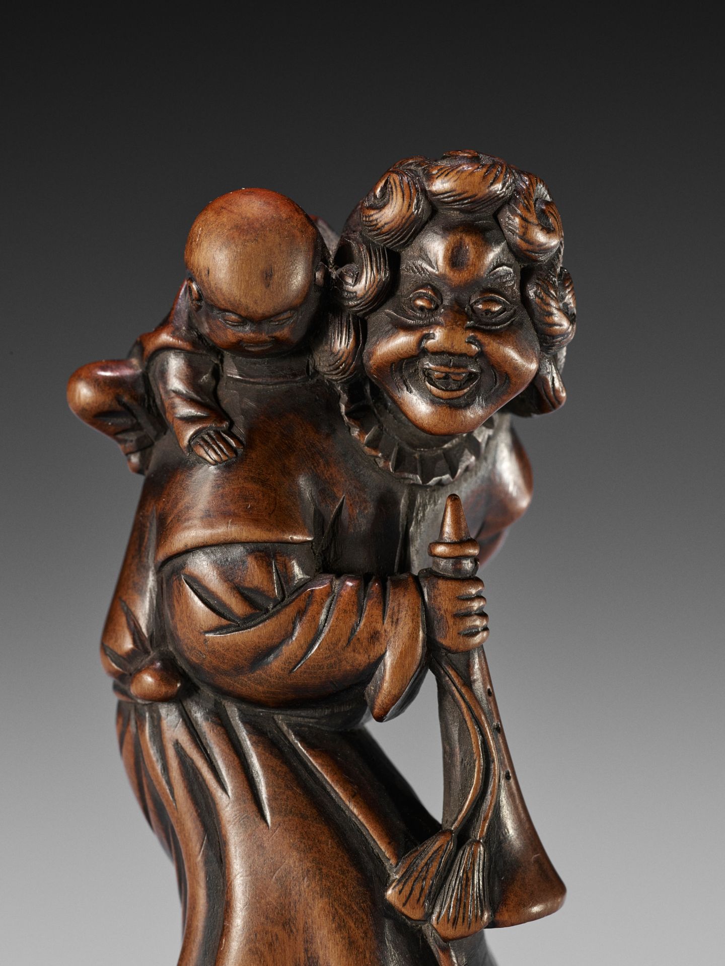 A GOOD WOOD NETSUKE OF A DUTCHMAN WITH CHILD