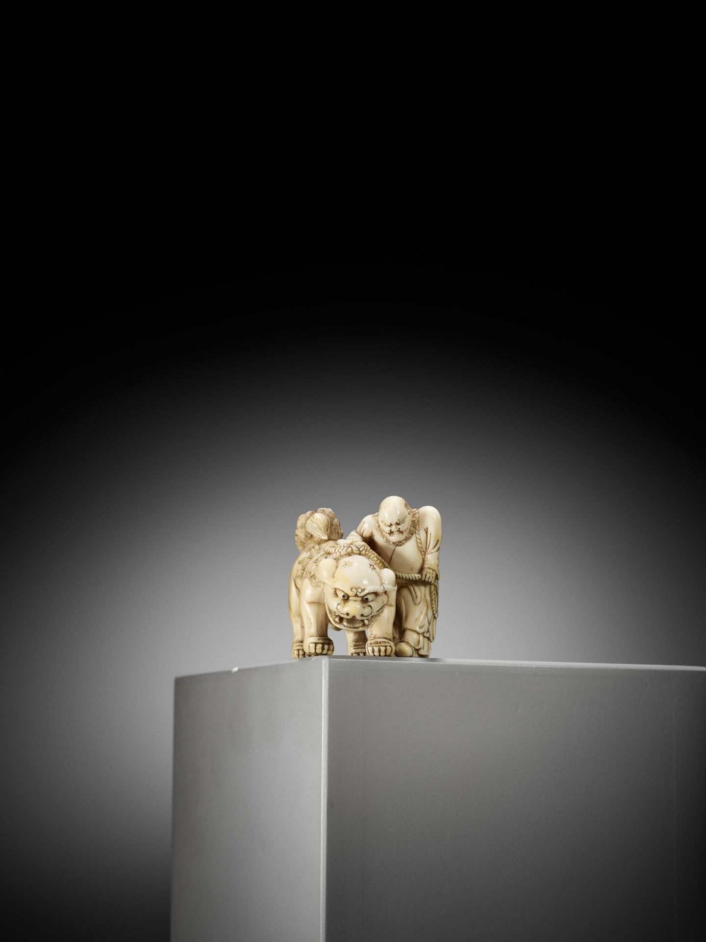 AN IVORY NETSUKE OF A FOREIGNER FROM SENHA LEADING A SHISHI - Bild 4 aus 12