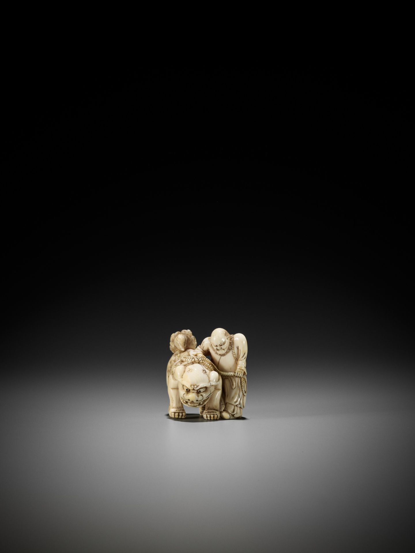 AN IVORY NETSUKE OF A FOREIGNER FROM SENHA LEADING A SHISHI - Bild 6 aus 12