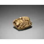 A WALRUS TUSK NETSUKE OF TURTLES AMONGST WAVES