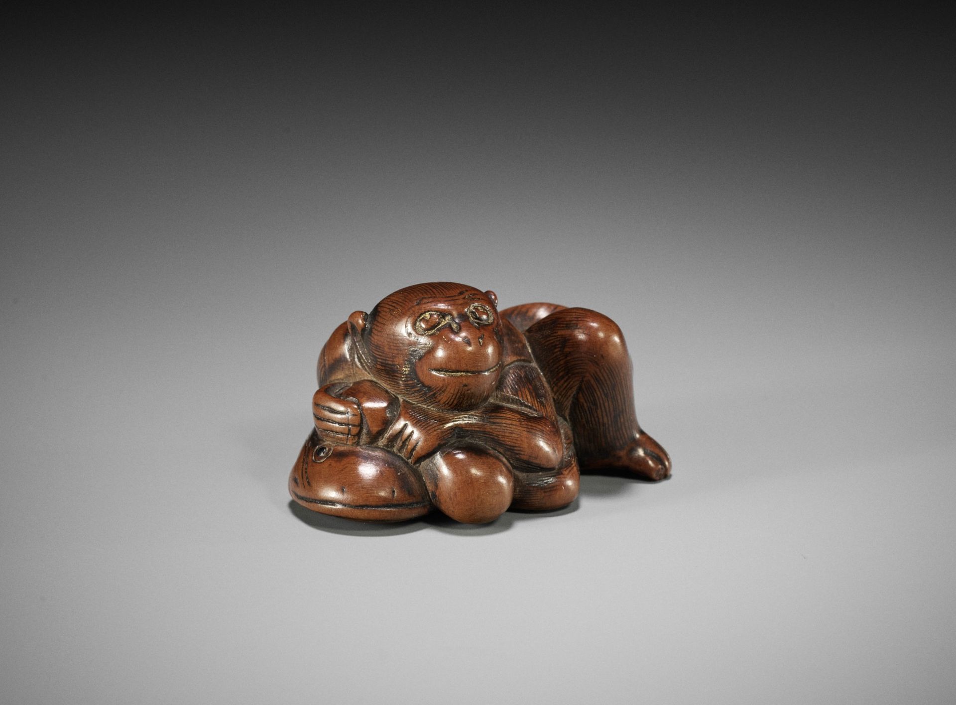 A WOOD NETSUKE OF A MONKEY, GOURD AND NAMAZU