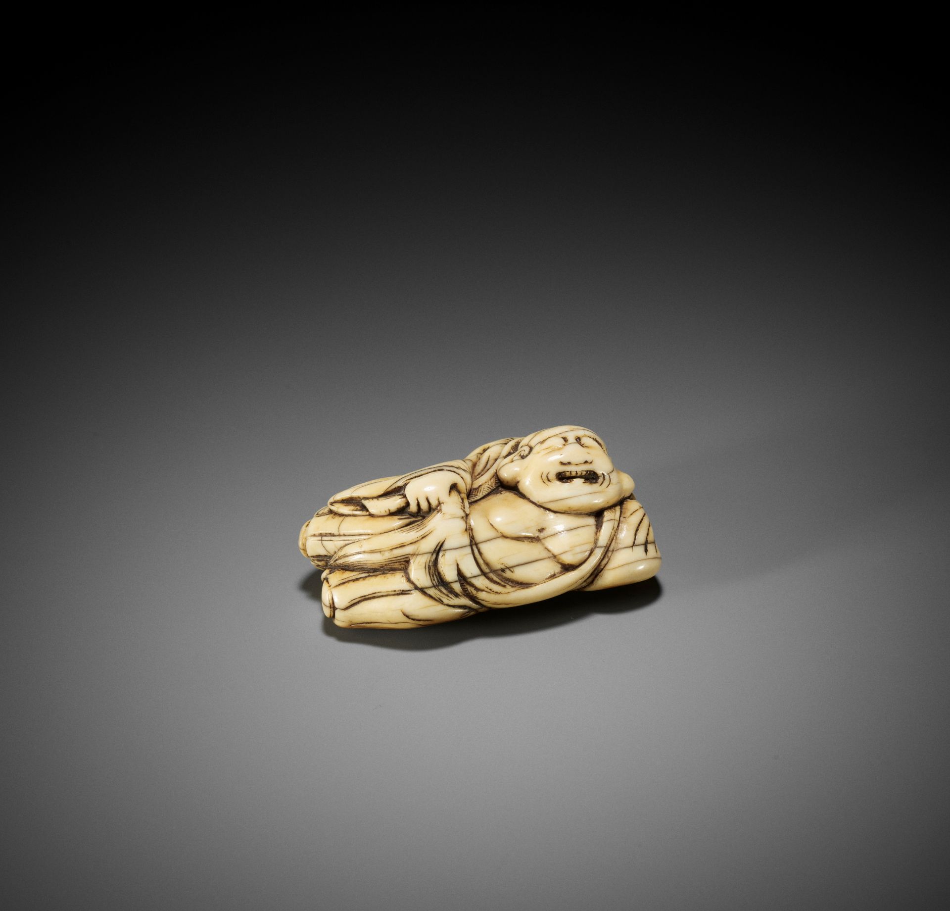 AN IVORY NETSUKE OF A RECLINING HOTEI WITH HOSSU (FLYWHISK) - Bild 2 aus 9