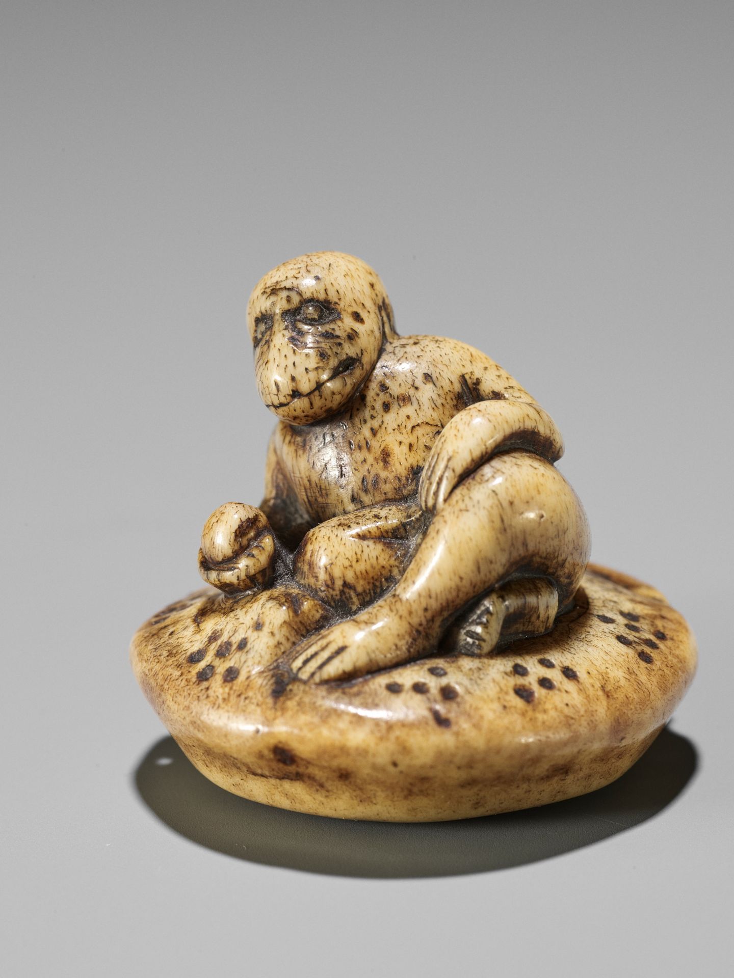A STAG ANTLER NETSUKE OF A MONKEY HOLDING A PEACH - Image 2 of 8