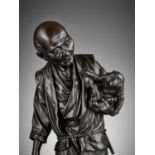 TAKAMITSU: A VERY FINE AND LARGE TOKYO SCHOOL BRONZE OKIMONO OF A MAN WITH A MONKEY