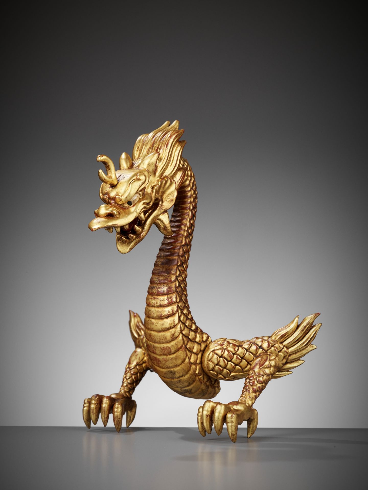 A RARE GOLD-LACQUERED WOOD MAEDATE IN THE FORM OF A DRAGON