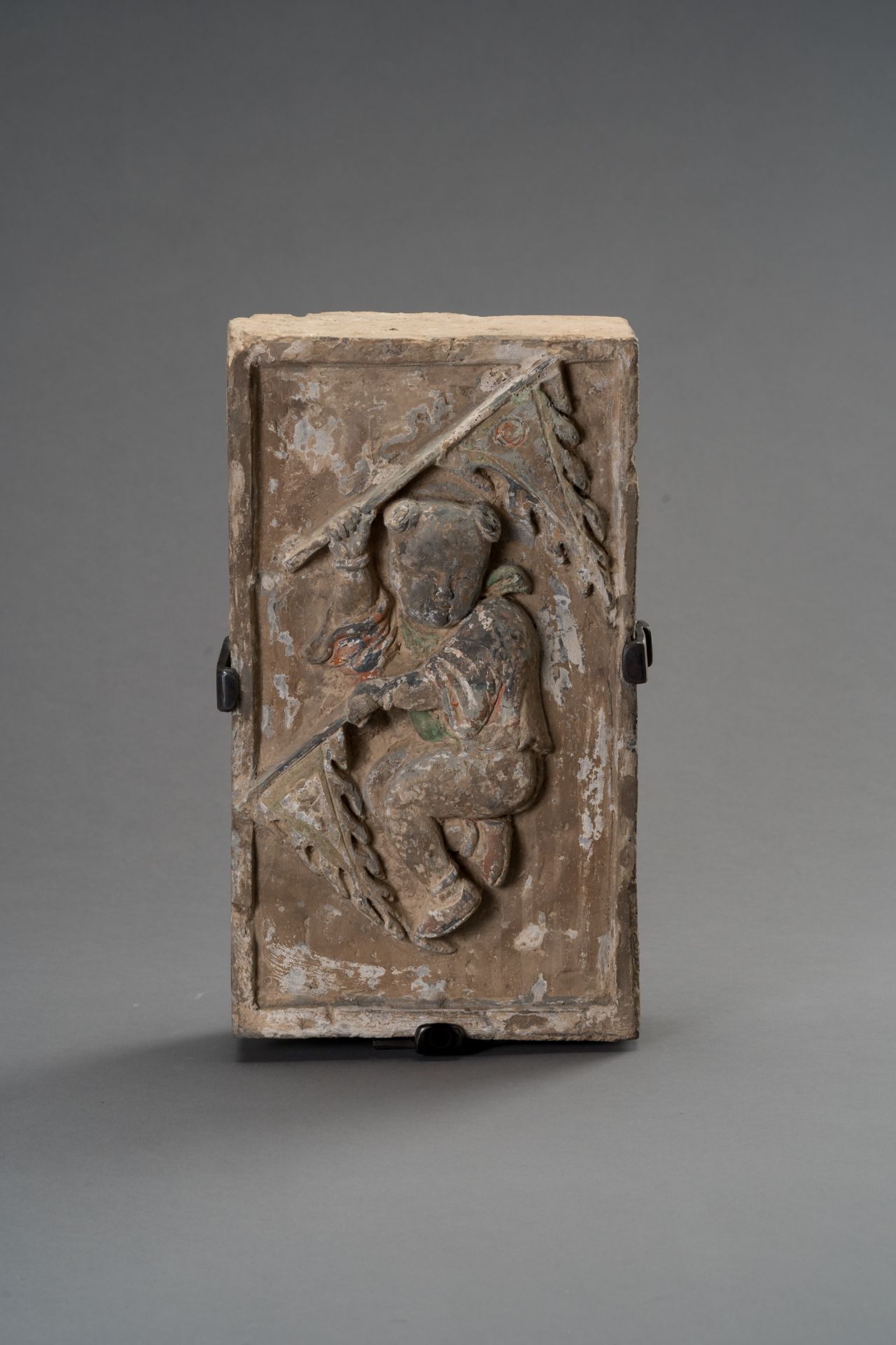 A TERRACOTTA WALL BRICK DEPICTING A CHILD WITH FLAGS, SONG DYNASTY