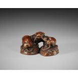 A FINE TANBA SCHOOL WOOD NETSUKE OF THREE PUPPIES AND AWABI SHELLS