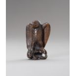 A WOOD NETSUKE OF AN EAGLE SNATCHING A RABBIT