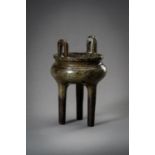 A BRONZE TRIPOD CENSER