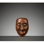 AN UNUSUAL WOOD MASK NETSUKE OF A GROTESQUE MAN