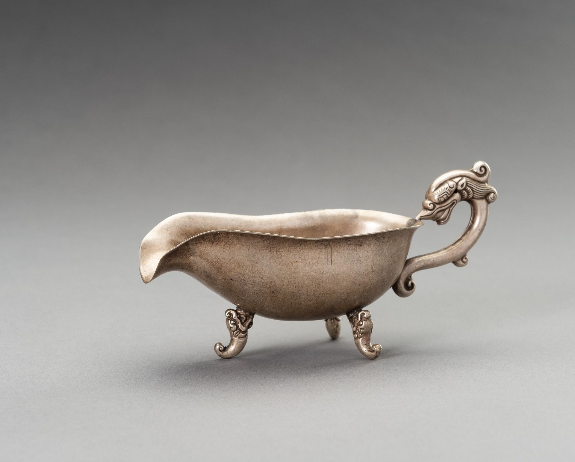 A METAL 'DRAGON' LIBATION CUP, 1930s