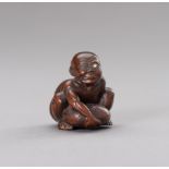 A WOOD NETSUKE OF A BLIND STONE LIFTER