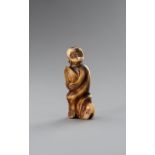 A STAG ANTLER NETSUKE OF A MONKEY HOLDING A PEACH