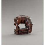 CHOZAN: A BOXWOOD NETSUKE OF A GRAZING HORSE