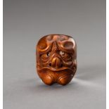 A BOXWOOD NETSUKE OF A YOKAI MASK