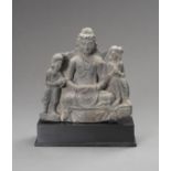 A GANDHARAN SCHIST FIGURE OF MAITREYA WITH ATTENDANTS