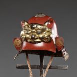 A RED-LACQUERED ZUNARI KABUTO WITH LION MASK MAEDATE