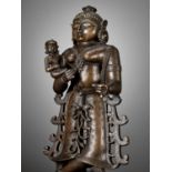 A LARGE BRONZE FIGURE OF YASHODA WITH KRISHNA AS A CHILD