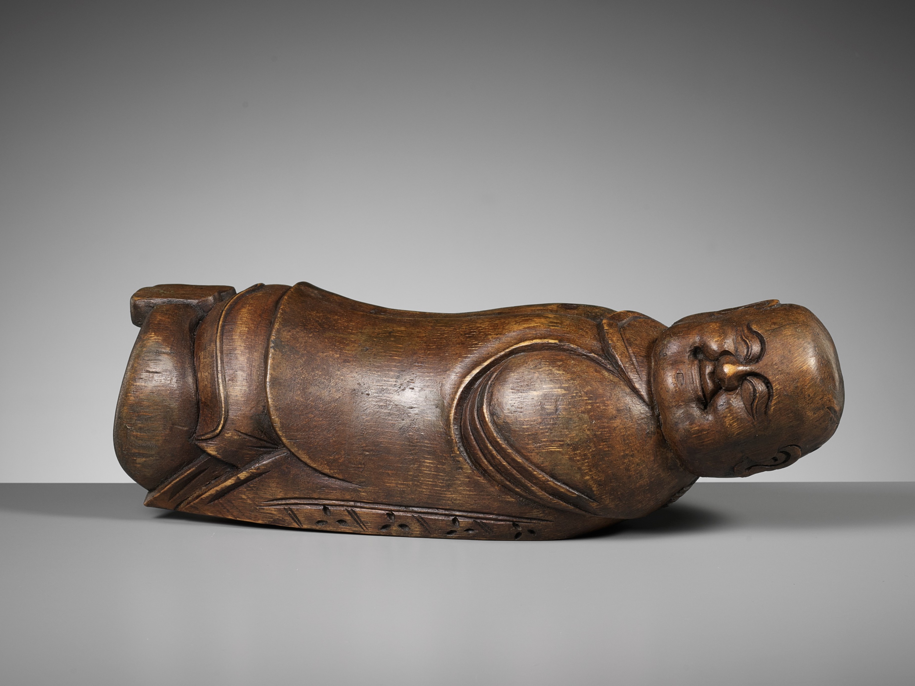 A CARVED BAMBOO 'SLEEPING BOY' PILLOW, QING DYNASTY