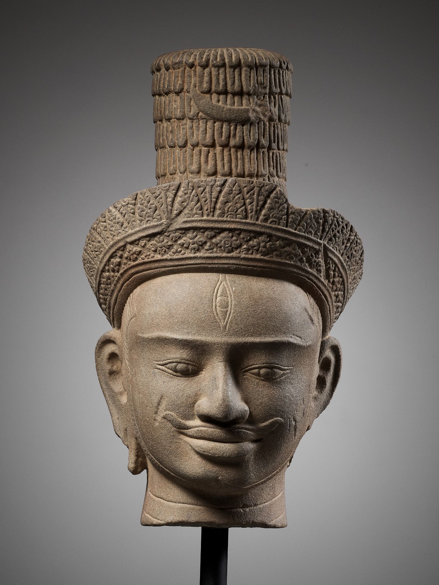 A SANDSTONE HEAD OF SHIVA, ANGKOR WAT STYLE