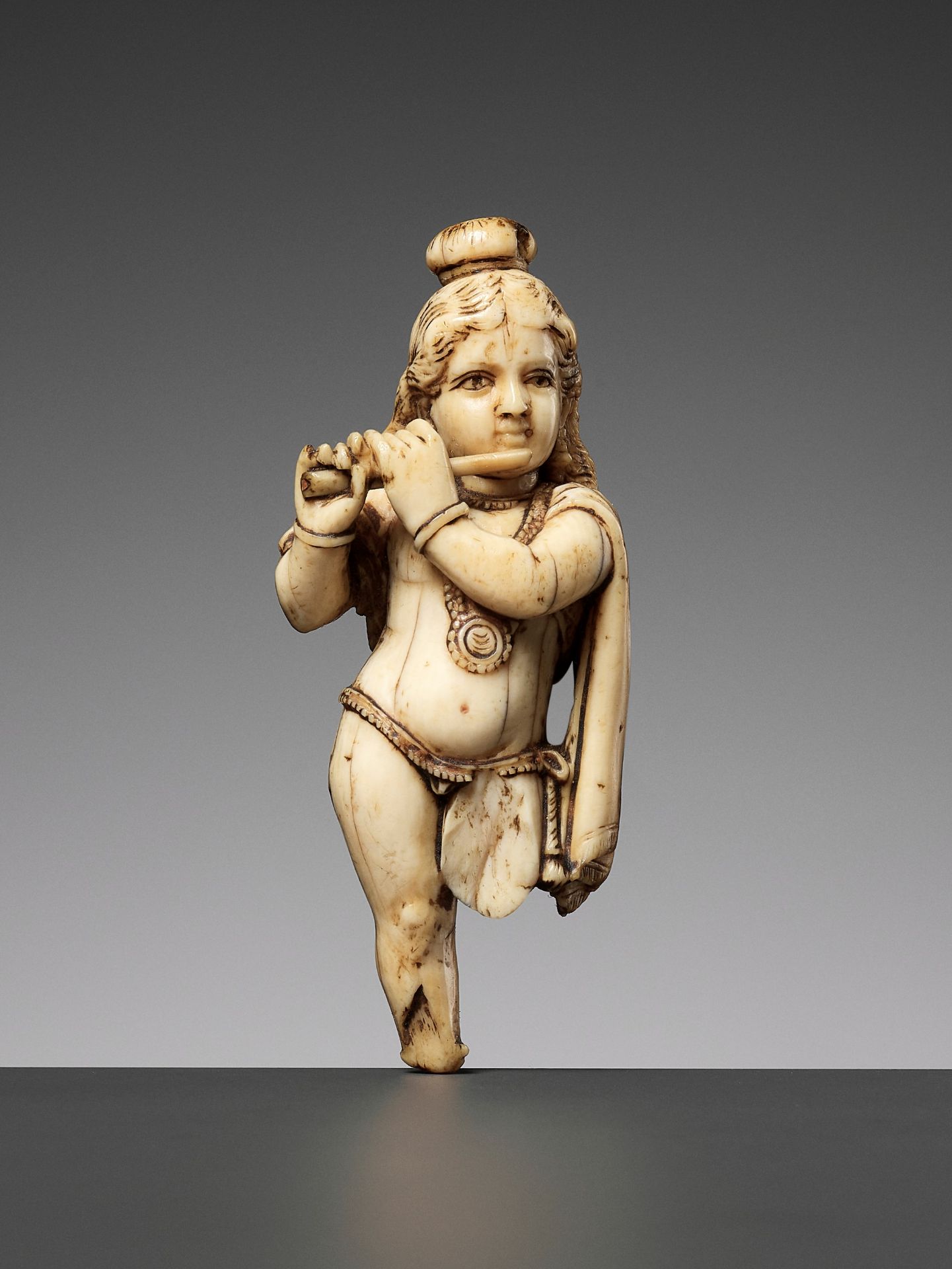 AN IVORY FIGURE OF KRISHNA VENUGOPALA, PLAYING THE FLUTE