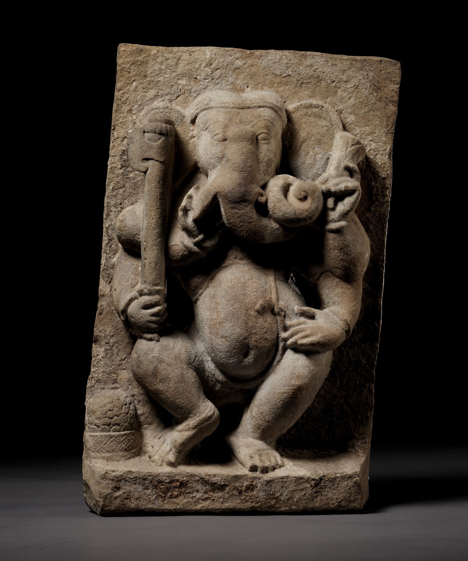 A BUFF SANDSTONE FIGURE OF DANCING GANESHA, MAHAGANAPATI, 10TH CENTURY