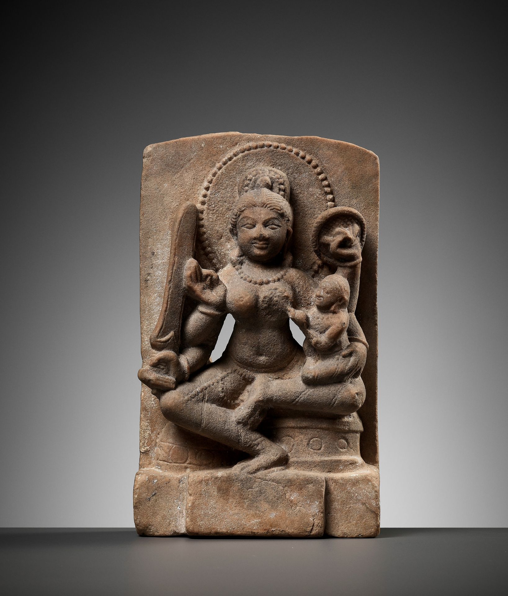 A RARE SANDSTONE MINATURE STELE FIGURE OF A MOTHER GODDESS WITH CHILD