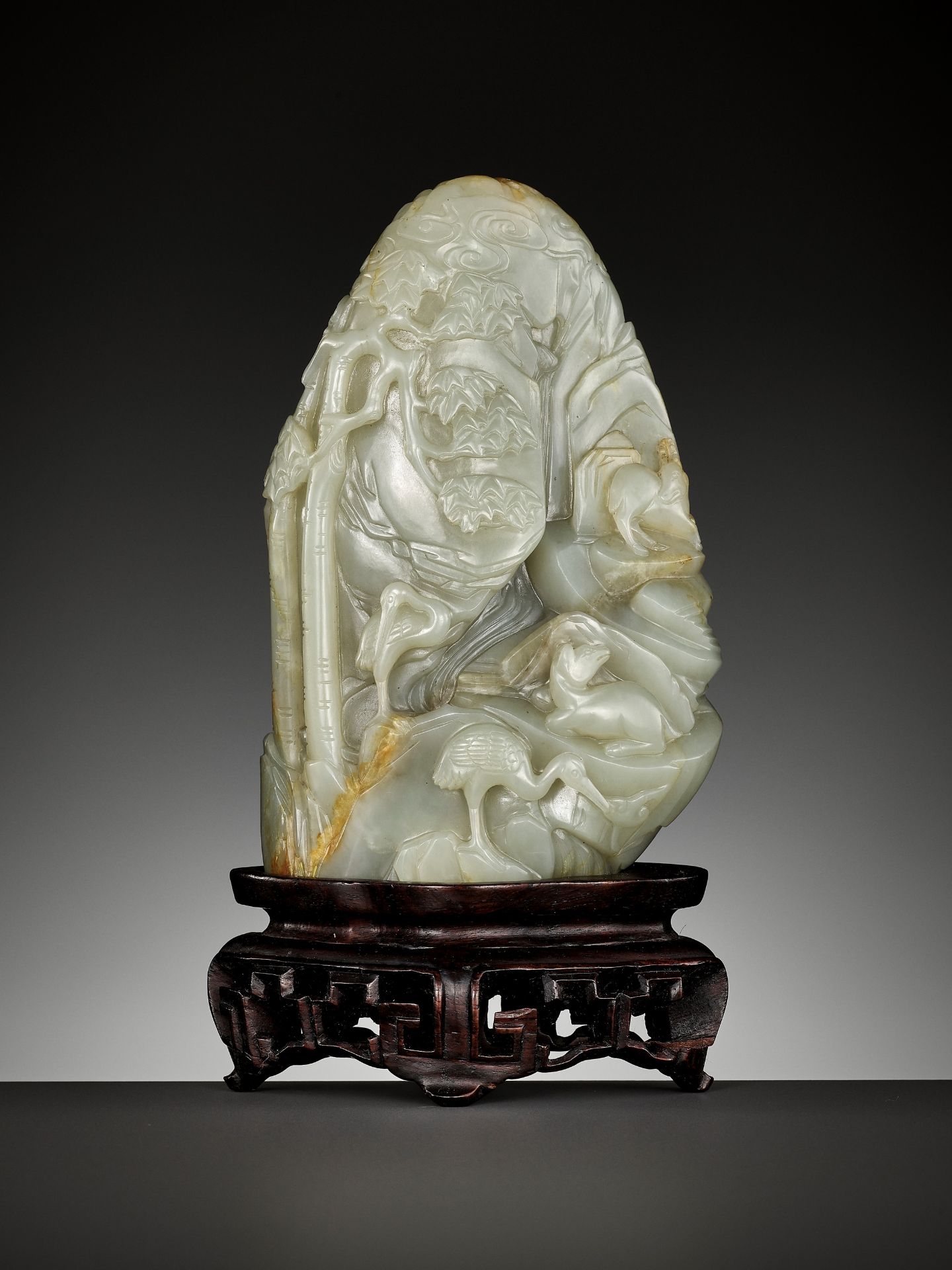 A CELADON AND RUSSET JADE 'DEER AND CRANE' BOULDER, 18TH CENTURY