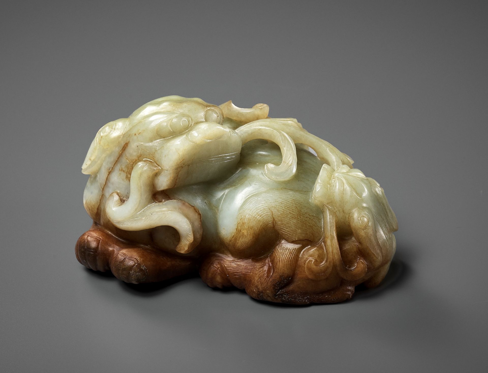 A CELADON AND RUSSET JADE 'BUDDHIST LION AND CUB' GROUP, 17TH CENTURY