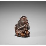 MASANAO: A FINE WOOD NETSUKE OF A MONKEY EATING PERSIMMONS