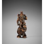 HACHIGYOKU: A RARE WOOD NETSUKE OF A SCULPTOR WITH NIO STATUE