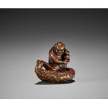 A POWERFUL EDO SCHOOL WOOD NETSUKE OF AN ONI STEALING A STUPA